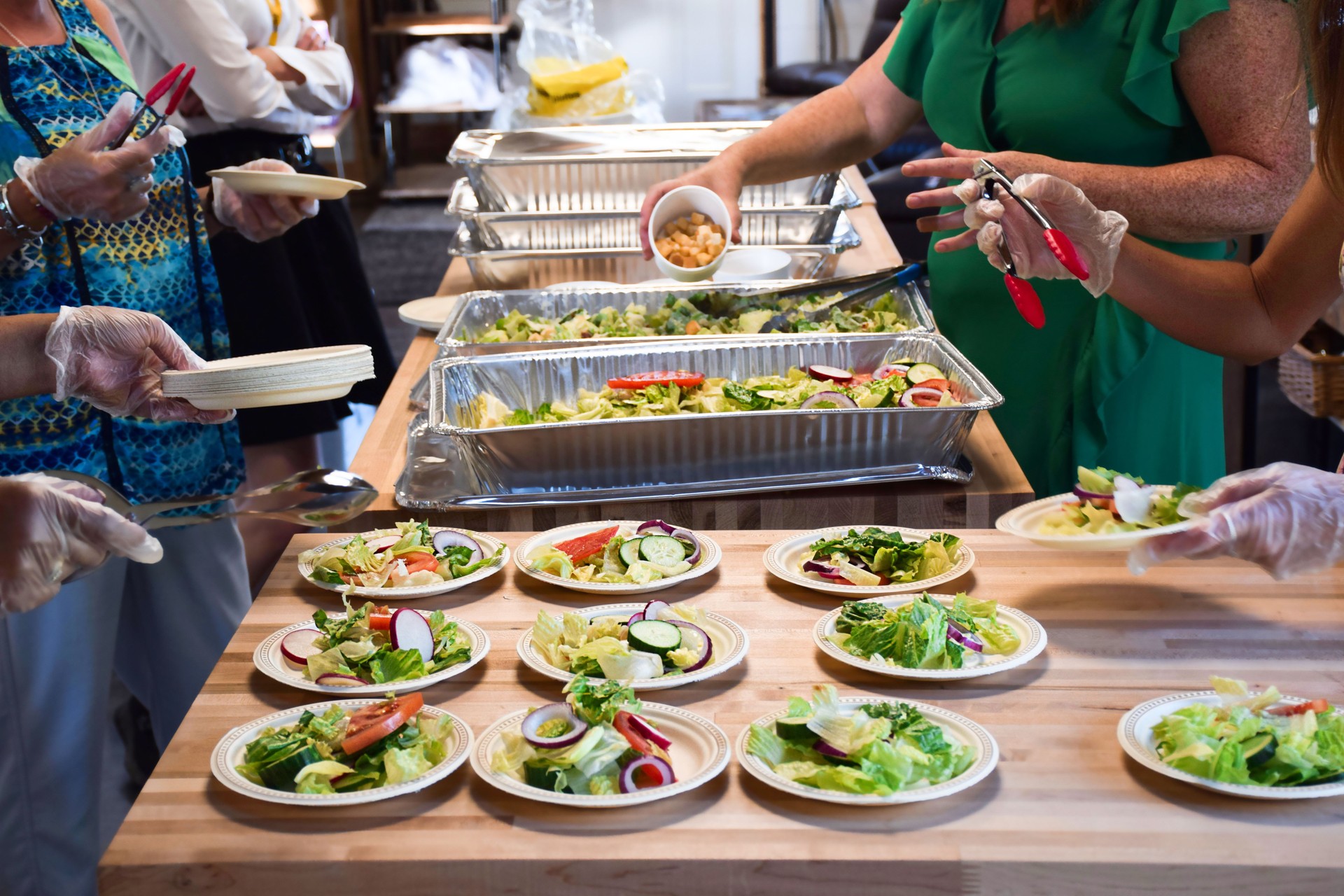 Women volunteers filling up plates with food at community event